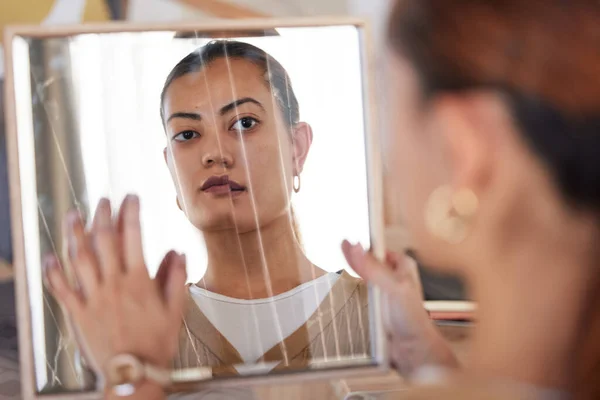 Woman with body dysphoria staring at a broken mirror